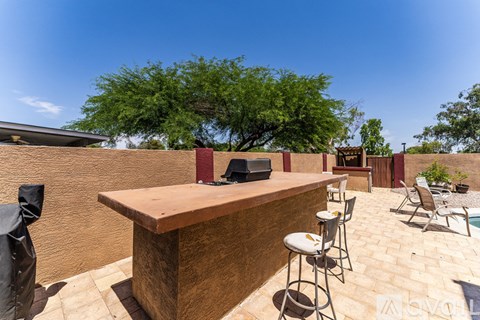 A patio with a bar and chairs is set up outside.