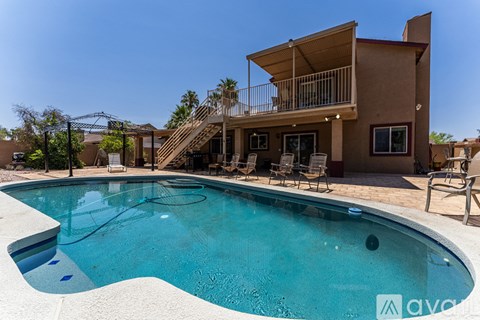 A pool in front of a house with a balcony.