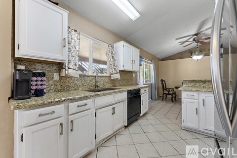 A kitchen with white cabinets and granite countertops.