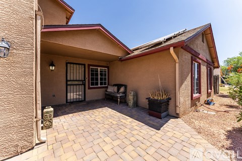 A house with a red roof and a patio with a table and chairs.