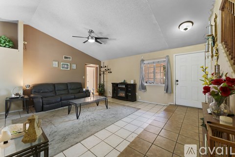 A living room with a black sofa and a glass coffee table.