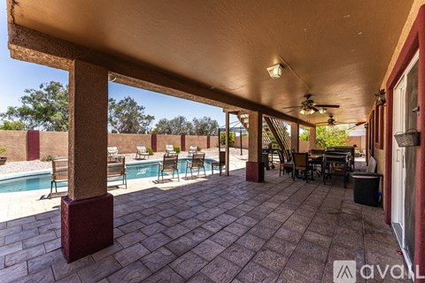 A patio with a table and chairs is covered by a roof.