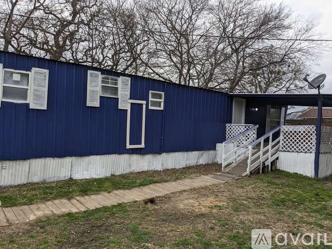 A blue building with white trim and a satellite dish on the roof.