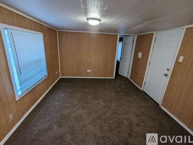 A room with wooden walls and carpeted floor.