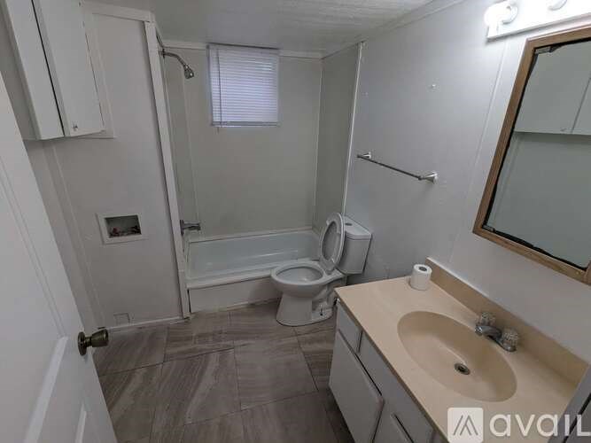 A bathroom with a toilet, sink, and shower.