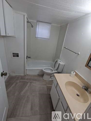 A bathroom with a toilet, sink, and bathtub.