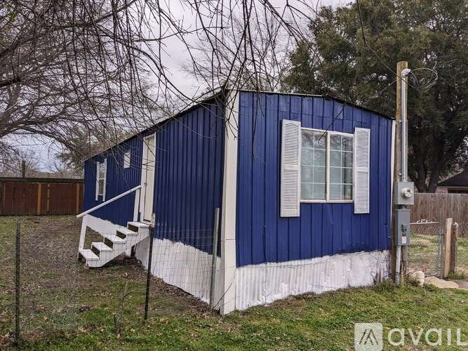 A blue house with white trim and a white fence.