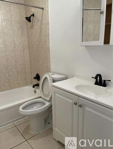 A white toilet is in a bathroom with a white sink.
