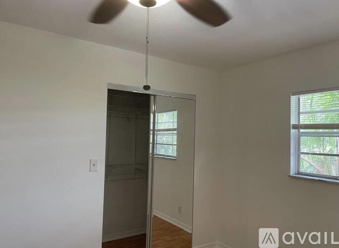 A room with a ceiling fan and a window.