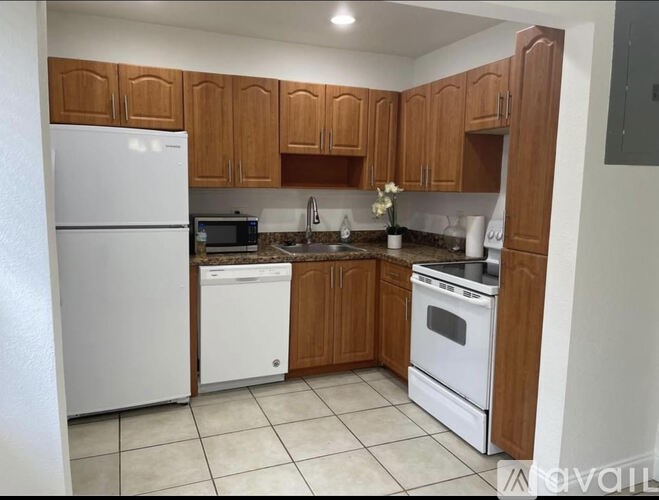 A kitchen with white appliances and wooden cabinets.