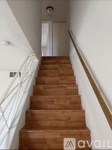 A staircase with wooden steps and white railings.