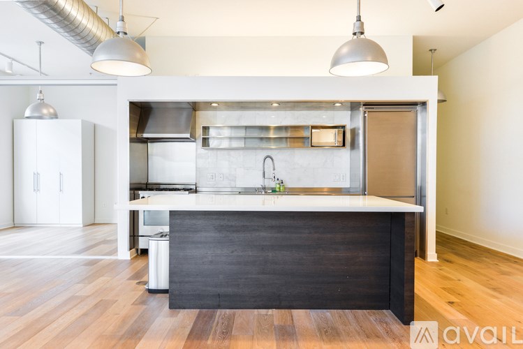 A modern kitchen with a large island and stainless steel appliances.