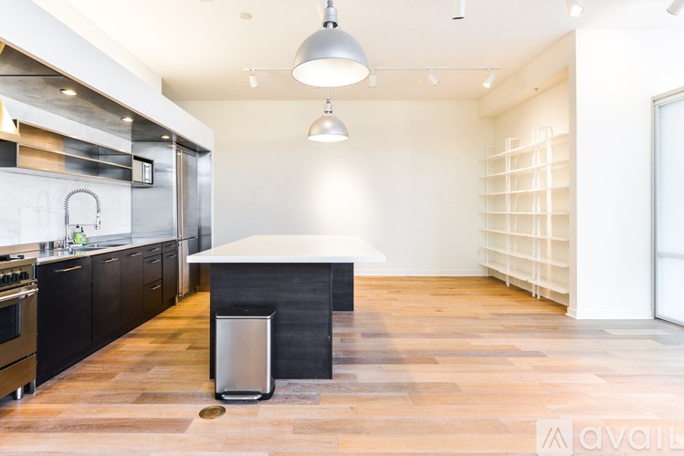 A kitchen with a black countertop and a stainless steel range hood.