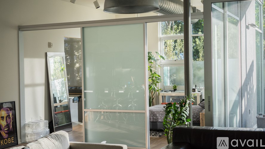 A glass wall separates the living room from the kitchen.
