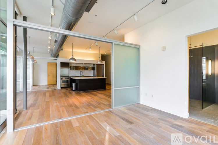 A modern kitchen with a wooden floor and a glass wall.