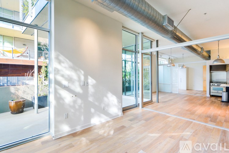 A room with wooden floors and a large window with sunlight coming through.
