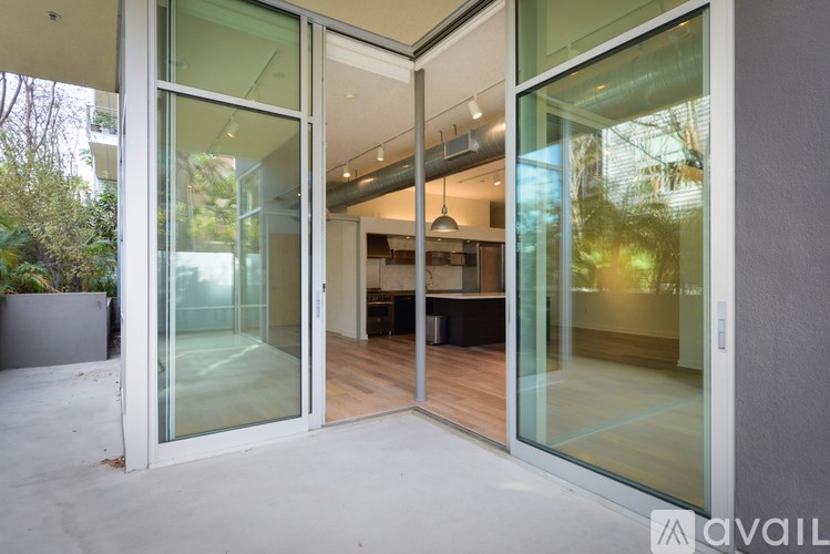 A modern house with glass doors and a kitchen visible inside.