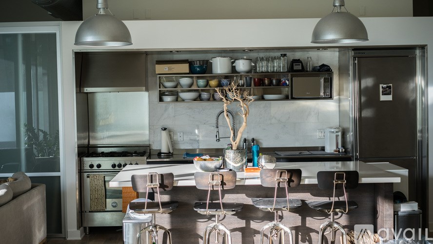 A kitchen with a stove, oven, and bar stools.