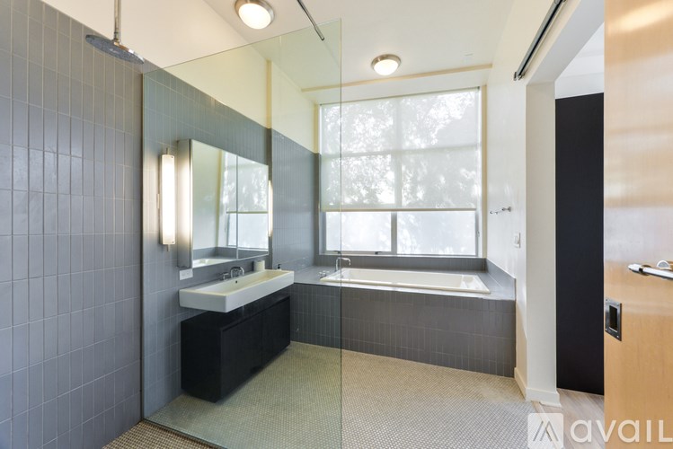 A bathroom with a sink, mirror, and bathtub.