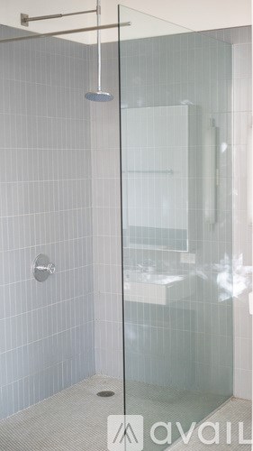 A glass shower door with a silver handle and a glass door.