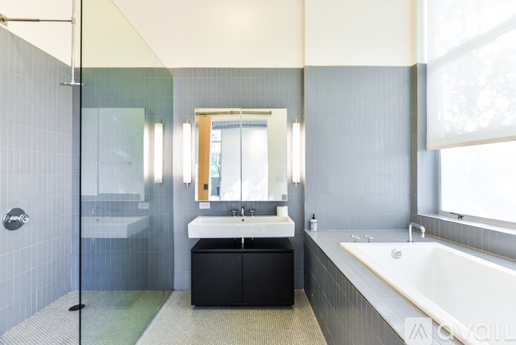 A modern bathroom with a white sink and a large mirror.