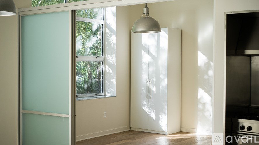 A modern kitchen with a sliding glass door leading to a balcony.