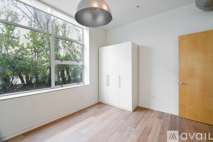 A room with a large window and a wooden floor.