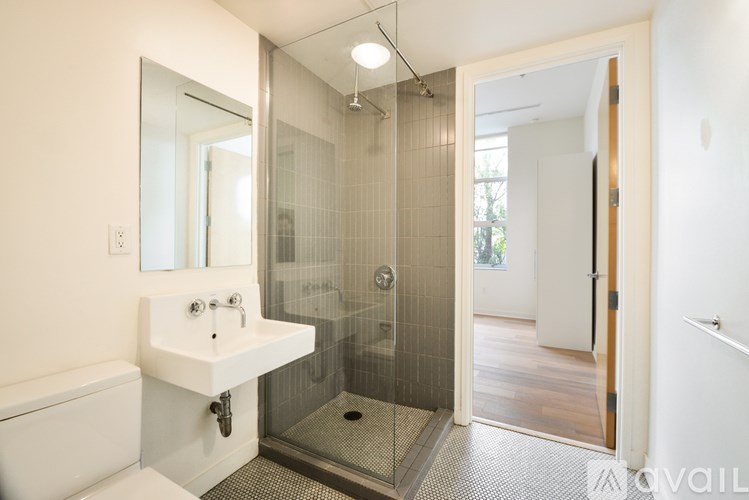 A bathroom with a walk in shower and a white sink.