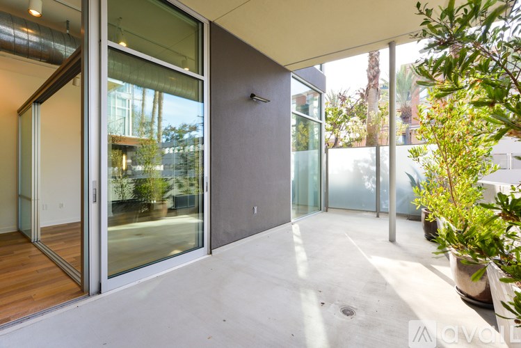 A patio area with a glass door and a grey wall.