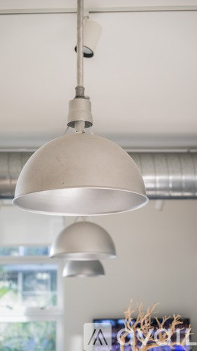 A silver pendant light hangs from a ceiling.