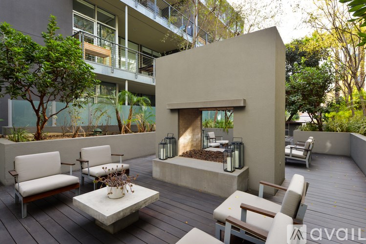 A patio with a white couch, a coffee table, and a fireplace.