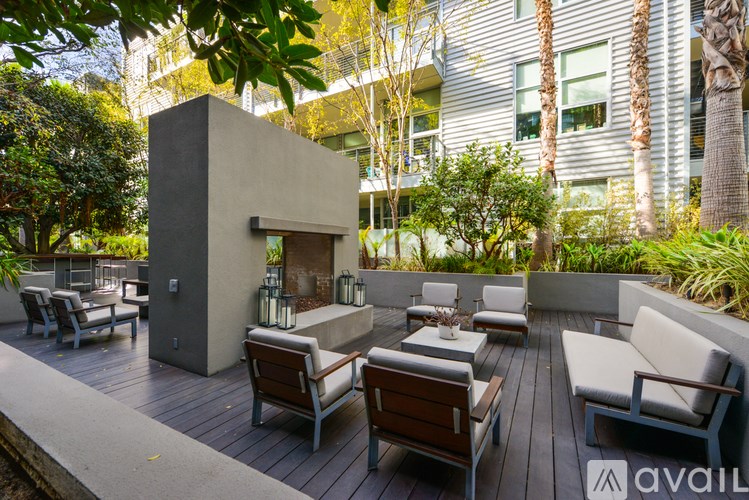A patio with wooden furniture and a concrete structure.