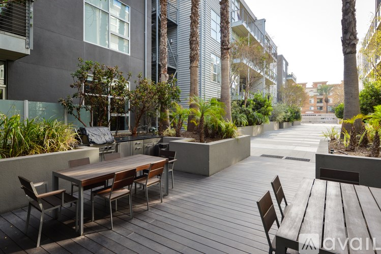A patio with a table and chairs surrounded by plants and trees.