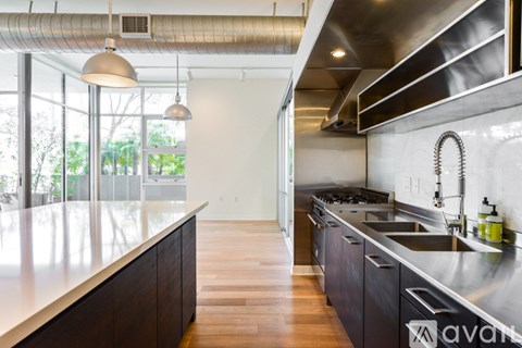 A modern kitchen with dark wood cabinets and stainless steel appliances.