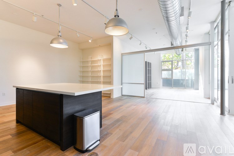 A modern kitchen with a large island and pendant lights.