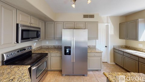 A kitchen with a stainless steel refrigerator in the middle.