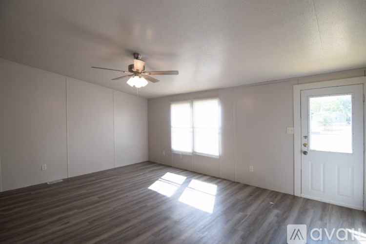 A room with a ceiling fan and wooden flooring.