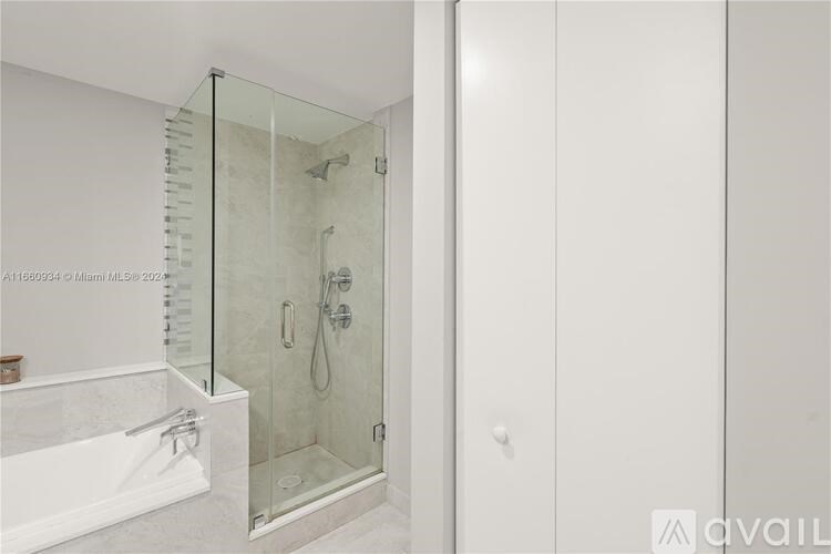 A white bathroom with a glass shower door.