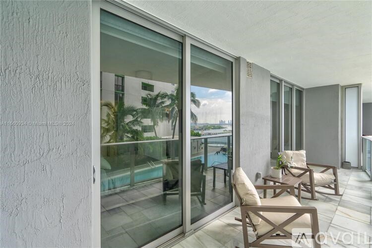 A patio with chairs and a table is visible through a glass door.