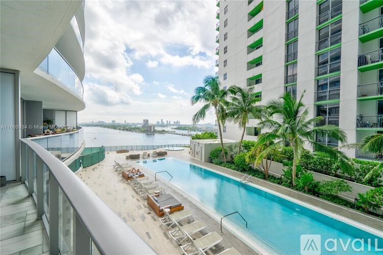 A balcony with a pool and palm trees.