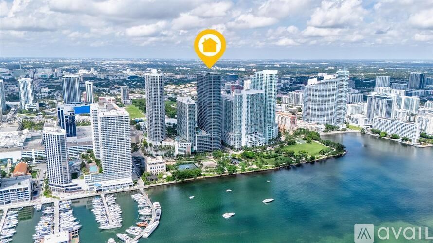 A cityscape with a waterfront and a boat marina.
