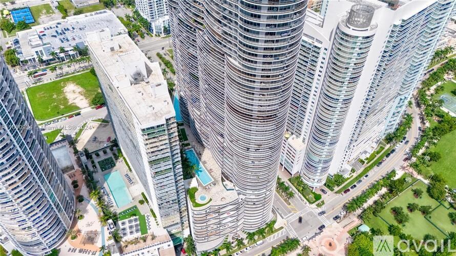 A bird's eye view of a cityscape with tall buildings and a pool in the foreground.