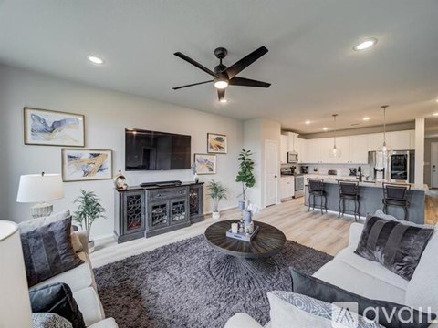 A living room with a grey rug and a white couch.