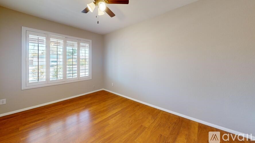 A room with wooden floors and a ceiling fan.
