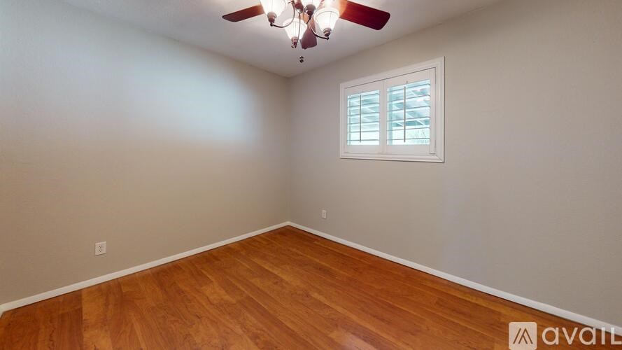 A room with wooden flooring and a ceiling fan.