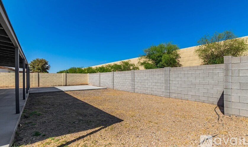 A wall of grey blocks is in the foreground of a sunny day.