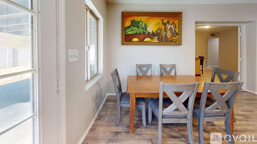 A dining room with a wooden table and chairs.