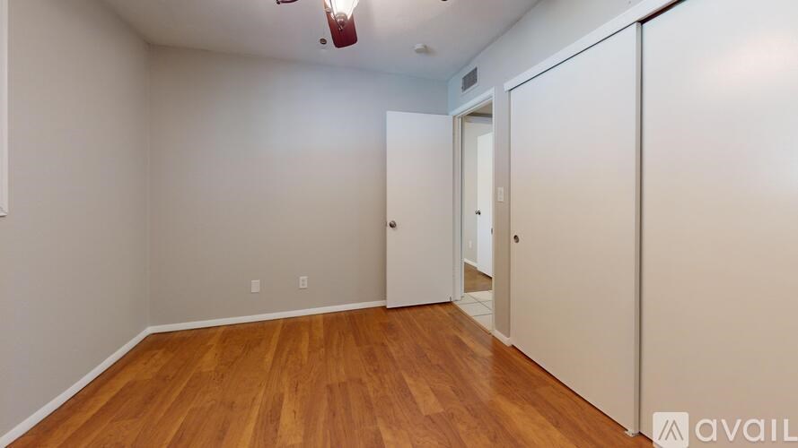 A room with wooden flooring and a white door.