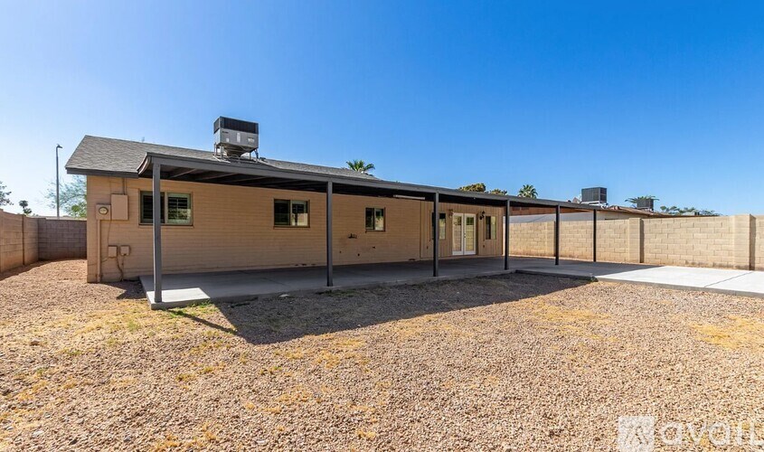 A house with a brown roof and a gravel driveway.