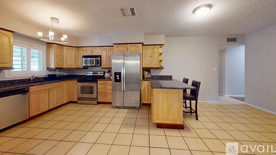 A kitchen with wooden cabinets and a tile floor.